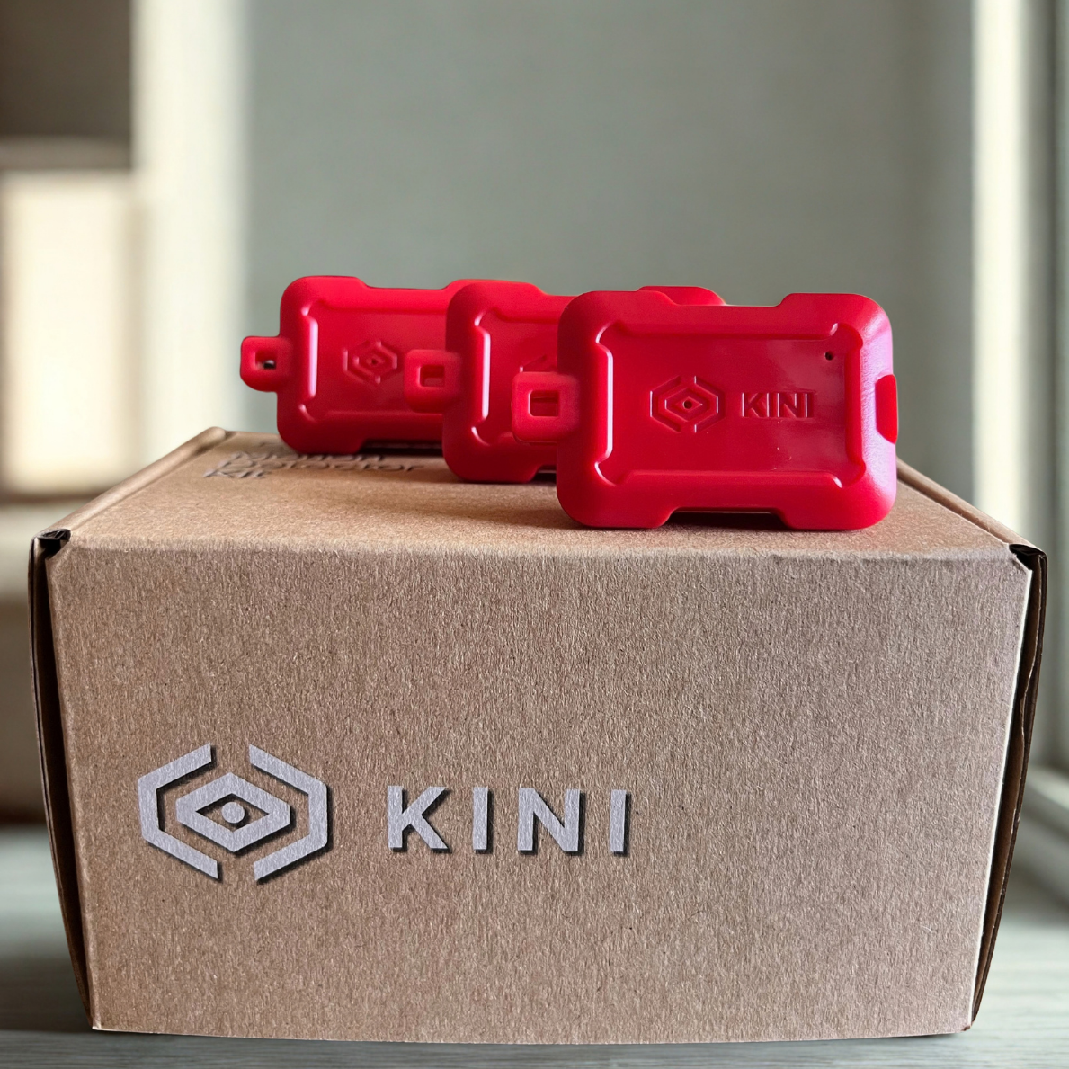 Three Candy Apple Red Kinis sitting on a Kini box