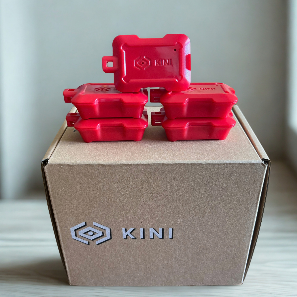 Five Candy-Apple Red Kinis sitting on a Kini Box
